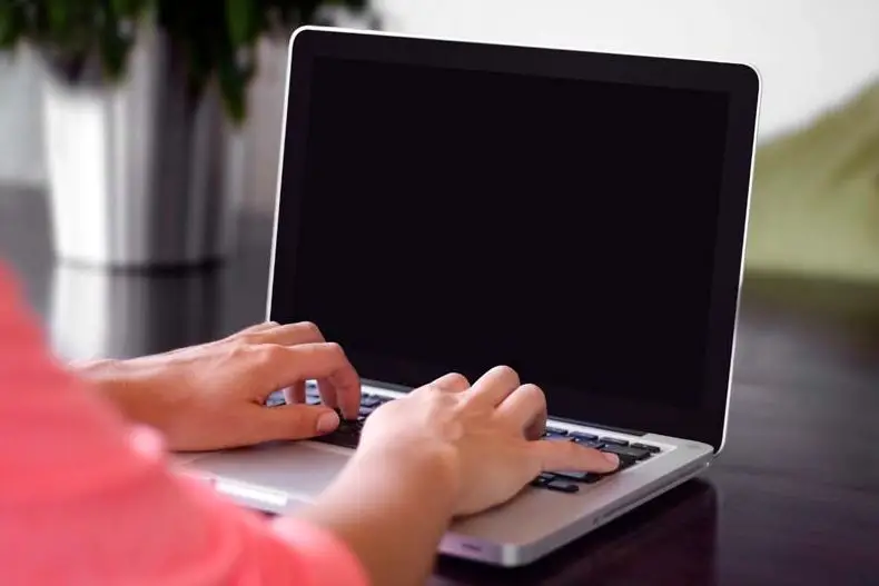 man typing on laptop